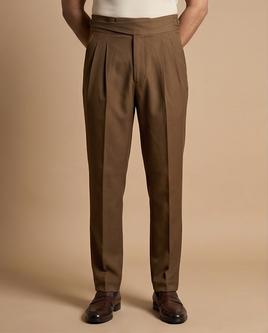 Brown pleated pants worn by a person on a beige background