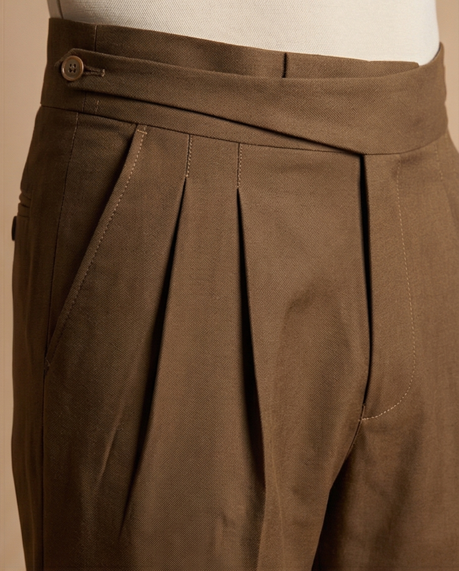 Close-up of brown pleated pants on a beige background