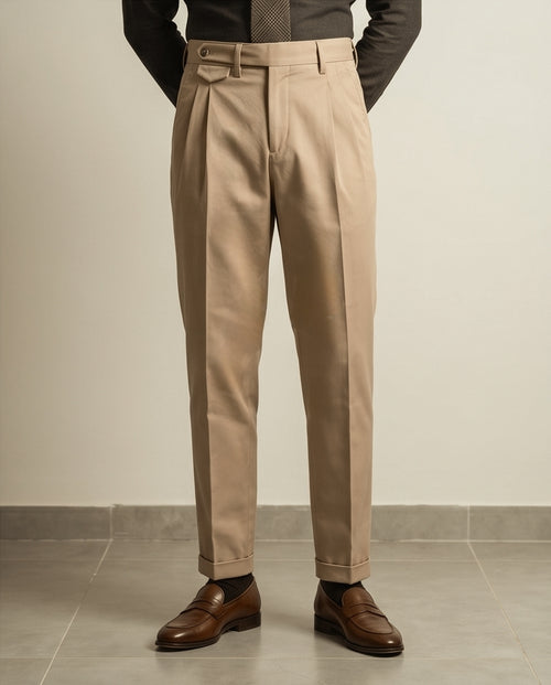 Beige dress pants worn by a person on a neutral background